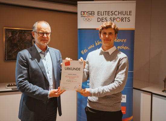 Helmut Augustin, stellvertretender Vorstandsvorsitzender der Sparkasse Rhein Neckar Nord (links), freut sich mit Hockeytalent Florian Simon (rechts) über dessen Auszeichnung als „Eliteschüler des Sports“.